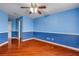 Large blue bedroom featuring hardwood floors, a ceiling fan, and a walk-in closet at 454 Venetian Villa Dr, New Smyrna Beach, FL 32168