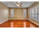 Cozy bedroom features hardwood floors, neutral paint, and plantation shutters for ample natural light at 454 Venetian Villa Dr, New Smyrna Beach, FL 32168