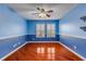 Spacious blue bedroom featuring beautiful hardwood floors, windows and custom trim work at 454 Venetian Villa Dr, New Smyrna Beach, FL 32168