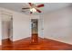 Bright bedroom featuring hardwood floors, ceiling fan, and walk-in closet with a view to an open doorway at 454 Venetian Villa Dr, New Smyrna Beach, FL 32168