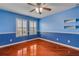 Beautiful blue bedroom featuring hardwood floors, windows and custom trim work at 454 Venetian Villa Dr, New Smyrna Beach, FL 32168