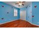 bedroom featuring hardwood floors, blue walls with Mickey Mouse decals and a ceiling fan at 454 Venetian Villa Dr, New Smyrna Beach, FL 32168