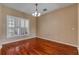 Bright dining room with hardwood floors, plantation shutters, and a charming chandelier at 454 Venetian Villa Dr, New Smyrna Beach, FL 32168