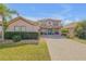 Beautiful two-story home with a well-manicured lawn, paver driveway and quaint front porch at 454 Venetian Villa Dr, New Smyrna Beach, FL 32168