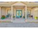 Inviting front porch with seating, a vibrant blue double-door entry, and decorative plants at 454 Venetian Villa Dr, New Smyrna Beach, FL 32168