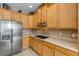 Modern kitchen featuring stainless steel refrigerator, tile backsplash, and ample cabinet space at 454 Venetian Villa Dr, New Smyrna Beach, FL 32168