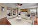 Bright and airy living room featuring hardwood floors, a ceiling fan, and access to the kitchen at 454 Venetian Villa Dr, New Smyrna Beach, FL 32168