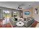 Staged living room with neutral furniture, hardwood flooring, ceiling fan, and access to the patio at 454 Venetian Villa Dr, New Smyrna Beach, FL 32168