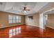 Spacious main bedroom with hardwood floors, tray ceilings, ceiling fan and plantation shutters on the windows at 454 Venetian Villa Dr, New Smyrna Beach, FL 32168