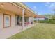 Charming covered patio with outdoor dining, lounge chairs, and string lights, perfect for entertaining at 454 Venetian Villa Dr, New Smyrna Beach, FL 32168