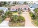 Aerial view of single-story home with brick driveway, green lawn, and mature landscaping at 4650 Saxon Dr, New Smyrna Beach, FL 32169