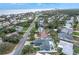 Beautiful aerial view of a coastal community with mature trees and a home with a private pool near the beach at 4650 Saxon Dr, New Smyrna Beach, FL 32169