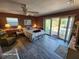 Main bedroom with sliding glass doors to patio, ceiling fan and wood-look tile at 4650 Saxon Dr, New Smyrna Beach, FL 32169