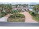 Aerial view of a charming home with brick driveway, lush landscaping, and a beautifully manicured front yard at 4650 Saxon Dr, New Smyrna Beach, FL 32169