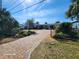 Brick paver driveway leads to charming ranch home with landscaped yard and gated entrance at 4650 Saxon Dr, New Smyrna Beach, FL 32169