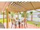 Cozy backyard patio with a wooden pergola, red deck, outdoor seating and a well-manicured lawn at 4650 Saxon Dr, New Smyrna Beach, FL 32169