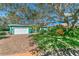 Single story home with lush landscaping and large oak tree at 50 Pompano Dr, Ponce Inlet, FL 32127