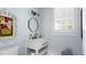 Stylish bathroom with a white vanity and octagonal mirror at 504 N Riverside Dr, New Smyrna Beach, FL 32168