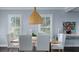 Bright dining room with modern light fixture and white chairs at 504 N Riverside Dr, New Smyrna Beach, FL 32168