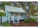 Quaint light blue cottage with a covered porch and fenced yard at 504 N Riverside Dr, New Smyrna Beach, FL 32168