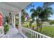 Relaxing white porch with rocking chairs and view of the street and trees at 504 N Riverside Dr, New Smyrna Beach, FL 32168