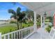 White front porch with rocking chairs, overlooking the street and water at 504 N Riverside Dr, New Smyrna Beach, FL 32168