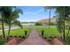 Brick pathway, lush landscaping, and waterfront view from the front yard at 504 N Riverside Dr, New Smyrna Beach, FL 32168