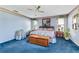 Spacious bedroom with blue carpet, a king-size bed, and ample natural light at 507 Boxwood Ln, New Smyrna Beach, FL 32168