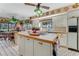 Galley kitchen with island, white cabinets, and tile flooring at 507 Boxwood Ln, New Smyrna Beach, FL 32168