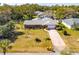 Single-story home with a large yard and driveway, aerial view at 51 Club House Blvd, New Smyrna Beach, FL 32168