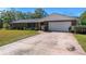 House exterior, brick facade, attached garage, and lawn at 51 Club House Blvd, New Smyrna Beach, FL 32168