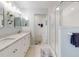 Bathroom featuring double sinks, granite countertops, and a glass-enclosed shower at 5300 S Atlantic Ave # 3-504, New Smyrna Beach, FL 32169