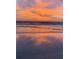 Beautiful sunset over the ocean with reflections on the wet sand, creating a serene beach view at 5300 S Atlantic Ave # 3-504, New Smyrna Beach, FL 32169