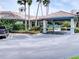 View of the community recreation center with lush landscaping, a porte-cochere and ample parking at 5300 S Atlantic Ave # 3-504, New Smyrna Beach, FL 32169