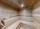 Inviting cedar sauna room featuring built-in benches and wood paneled walls and ceiling at 5300 S Atlantic Ave # 3-504, New Smyrna Beach, FL 32169