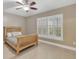 Light and airy bedroom with wood bed frame and tile floors at 610 Renner Rd, Port Orange, FL 32127