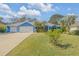 Blue house with metal roof, three-car garage, and landscaped yard at 610 Renner Rd, Port Orange, FL 32127