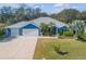 Blue house with metal roof, three-car garage, and landscaped yard at 610 Renner Rd, Port Orange, FL 32127