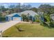 Blue house with metal roof, three-car garage, and landscaped yard at 610 Renner Rd, Port Orange, FL 32127