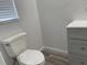 Bathroom featuring white toilet, modern gray vanity, and a bright window at 621 Middlebury Loop, New Smyrna Beach, FL 32168