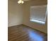 Bedroom featuring modern wood-look floors and a window with privacy blinds at 621 Middlebury Loop, New Smyrna Beach, FL 32168