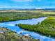 Scenic aerial view of a coastal waterway with vibrant greenery and tranquil waters at 634 N Riverside Dr, New Smyrna Beach, FL 32168