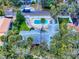 Aerial view featuring a private pool, lush trees, and surrounding fenced yard at 634 N Riverside Dr, New Smyrna Beach, FL 32168