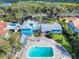 Stunning aerial view of coastal home with pool, mature trees, and waterway access at 634 N Riverside Dr, New Smyrna Beach, FL 32168