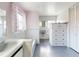 Full bathroom with white tile walls, flamingo-themed curtains, blue floors, and built-in storage at 634 N Riverside Dr, New Smyrna Beach, FL 32168