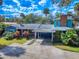 Charming exterior showcasing a unique, multi-level home with a carport and landscaped yard at 634 N Riverside Dr, New Smyrna Beach, FL 32168