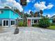 This home boasts a colorful front door, lush landscaping, and a tropical, backyard at 634 N Riverside Dr, New Smyrna Beach, FL 32168