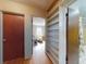 Hallway with hardwood floors leading to a bedroom with built-in shelves and the main bathroom at 634 N Riverside Dr, New Smyrna Beach, FL 32168