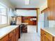 A kitchen with wood cabinets, white countertops, and modern appliances leading into a wood-paneled room at 634 N Riverside Dr, New Smyrna Beach, FL 32168