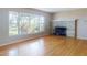 Hardwood floored living room with a stone fireplace and a large bright window at 634 N Riverside Dr, New Smyrna Beach, FL 32168